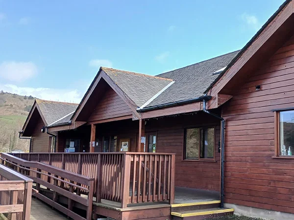 Front of Grizebeck Community Hall showing the accessible parking space, entrance steps and wheelchair ramp